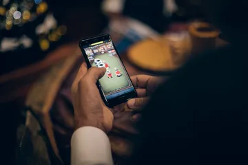 একজন পুরুষ তার ল্যাপটপে জয়ের মুহূর্ত উদযাপন করছেন, চারপাশে ভাসছে গেমিং আইকন—যা 8777BEF গেমসের উত্তেজনাকে প্রকাশ করে।